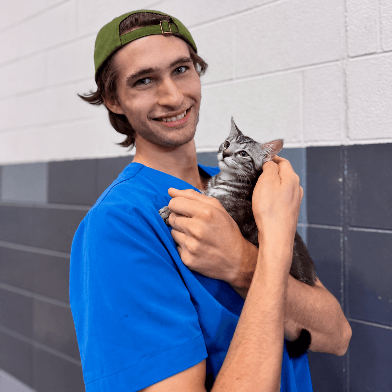 Public Vet team member Elijah holding a kitten
